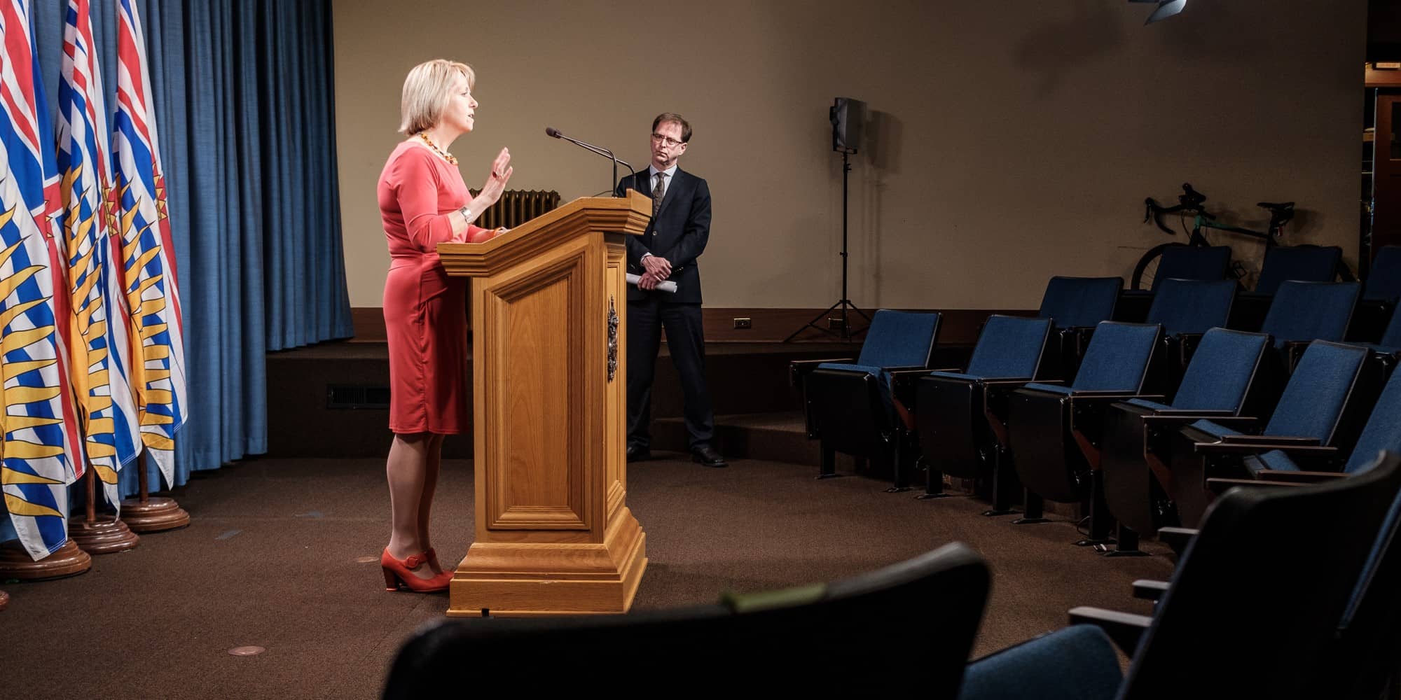BC provincial officer of health Bonnie Henry delivers a COVID-19 update to an empty auditorium (BC Ministry of Health).