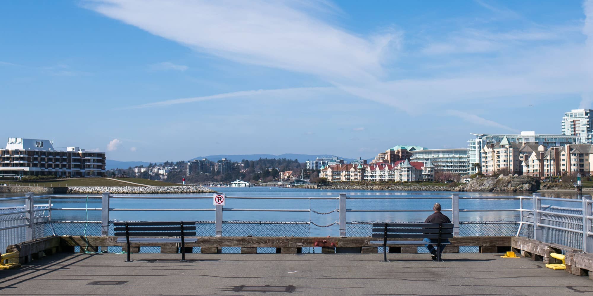 A lone man on a bench overlooks a now-empty harbour that in non-pandemic conditions typically ranks as one of the busiest waterways in Canada (James MacDonald for The Capital).