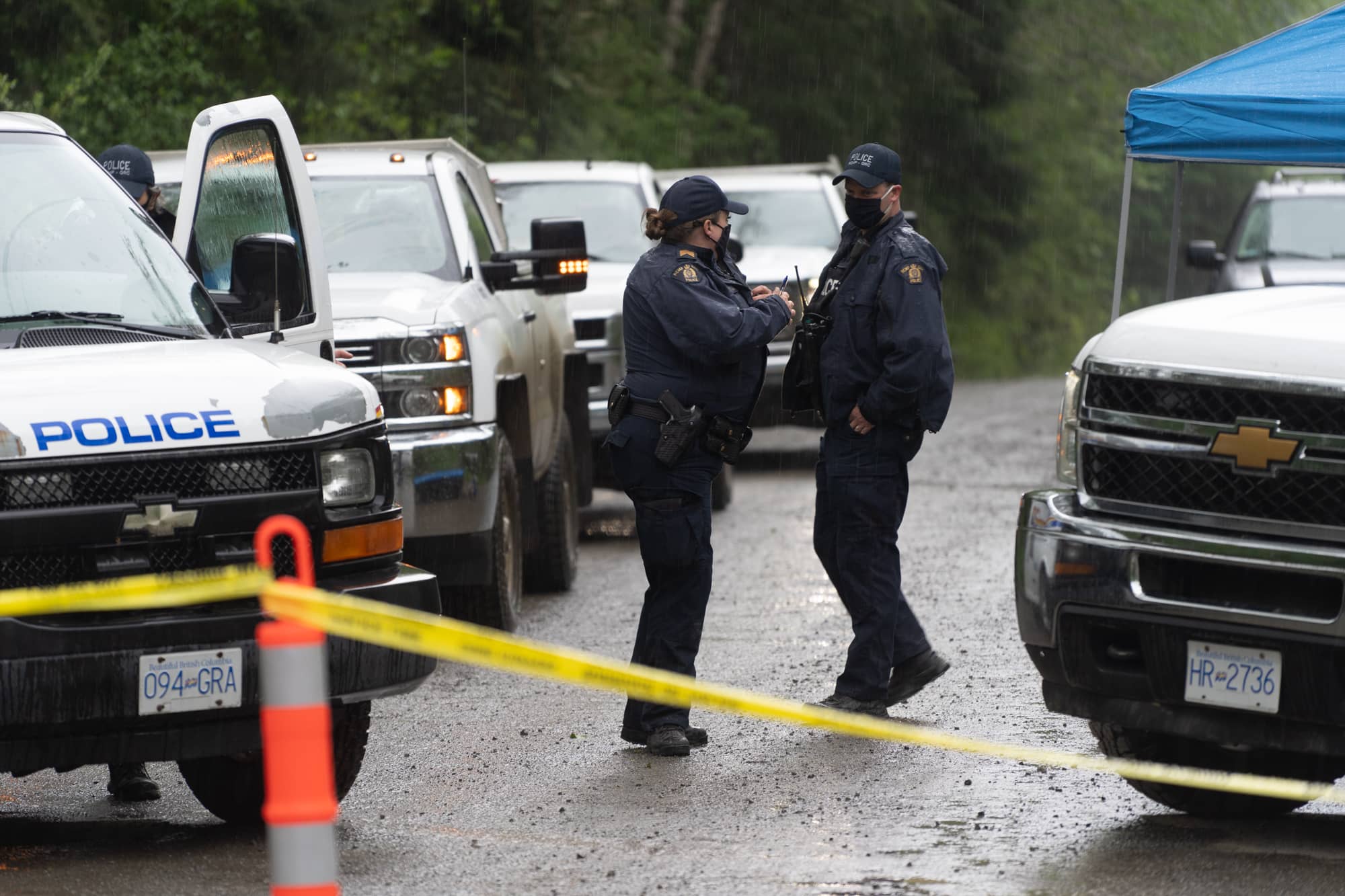 Two RCMP officers blocking the road on the first day of the injunction, May 23, 2021. The officers did not let media cross into the enforcement area; now the judge has ruled that conduct, among other factors, has harmed the reputation of the court. Photo: Jimmy Thomson / Capital Daily