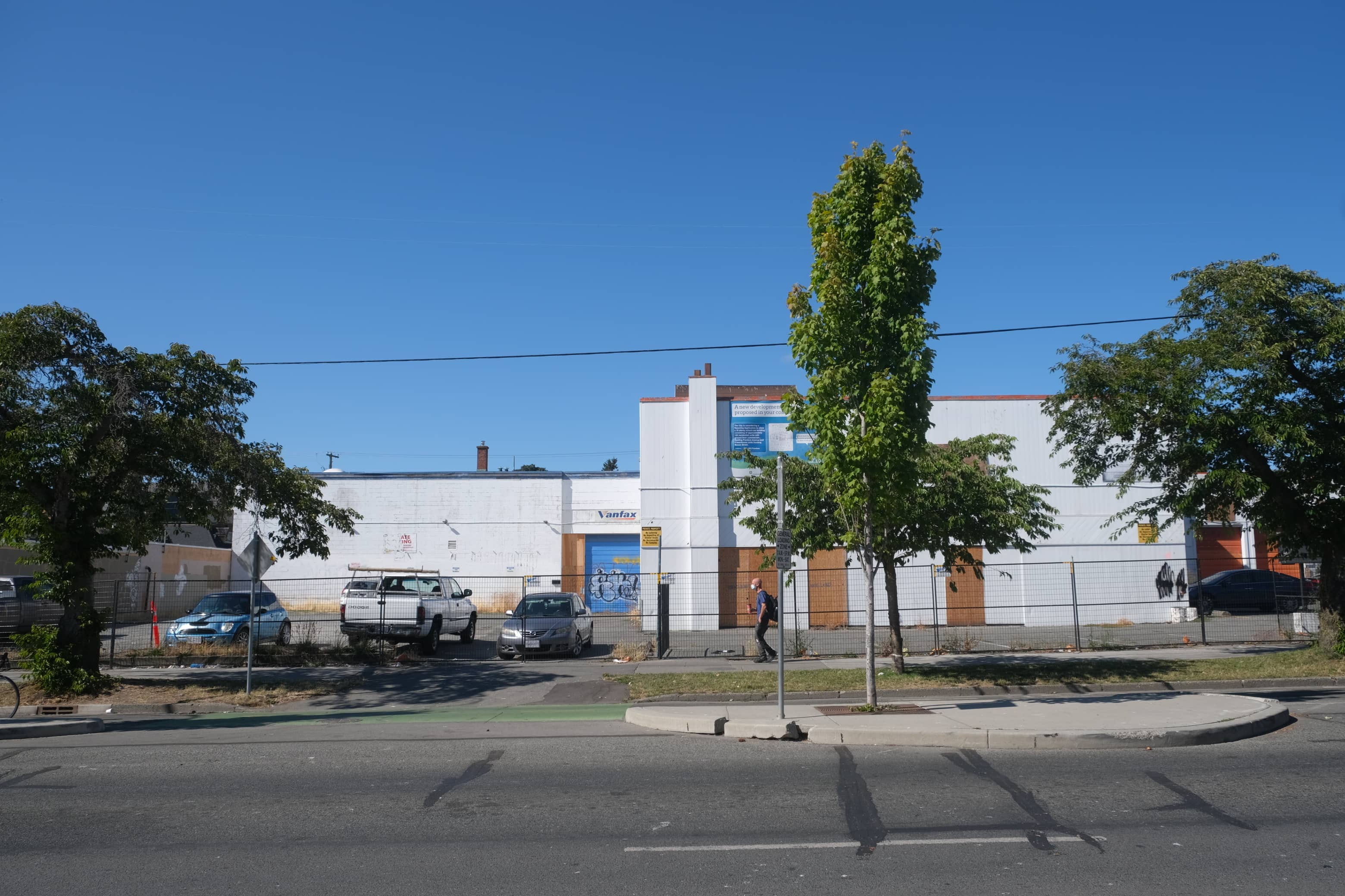 A pedestrian walks beside the boarded up building currently located at 926 and 930 Pandora Avenue. Photo: Michael John Lo / Capital Daily