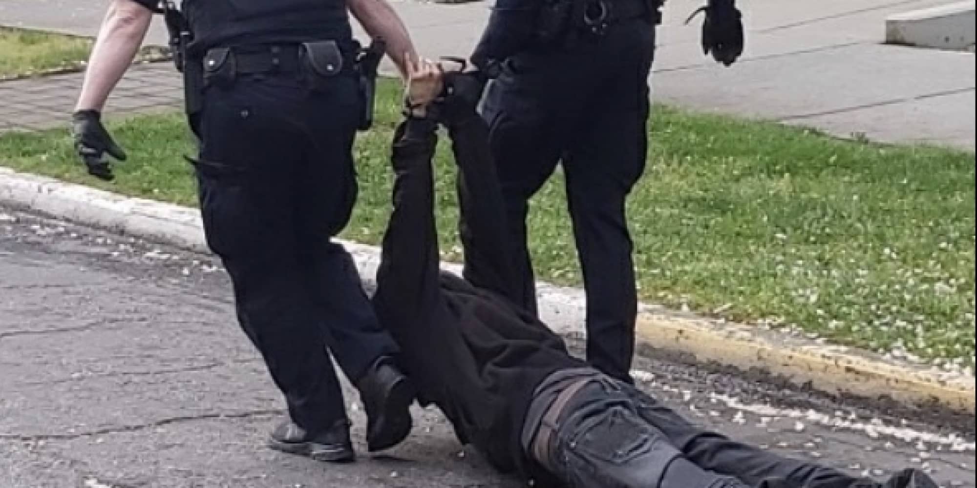 Two Victoria Police officers pictured dragging a suspect into custody on May 12 (Submitted)