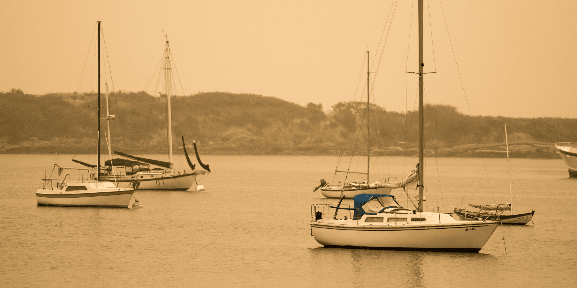 An orange haze enshrouds these sailboats anchored just off Victoria's coast (James MacDonald for The Capital).