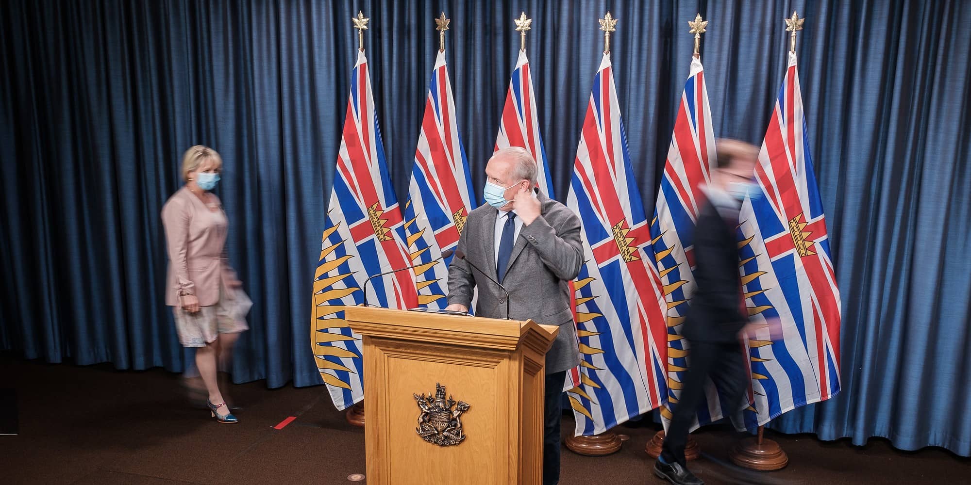 A masked Premier John Horgan delivers remarks earlier this month regarding BC's fall pandemic preparedness. To his right is Provincial Health Officer Bonnie Henry, and at his left is Minister of Health Adrian Dix (BC Ministry of Health).