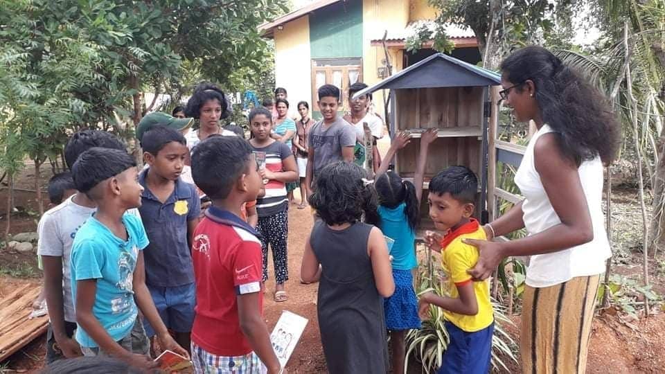 Children gather around the little library Karunarathna helped build in her community in Talawa, Sri Lanka. Photo: Submitted