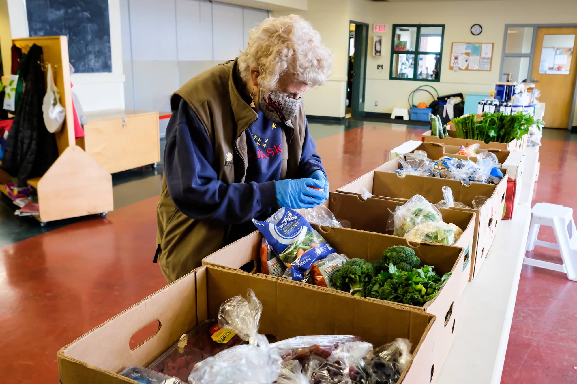 Volunteer Barb Coates packs boxes for families in need at the Oakland food pantry. Photo: Sandy Yong (submitted)