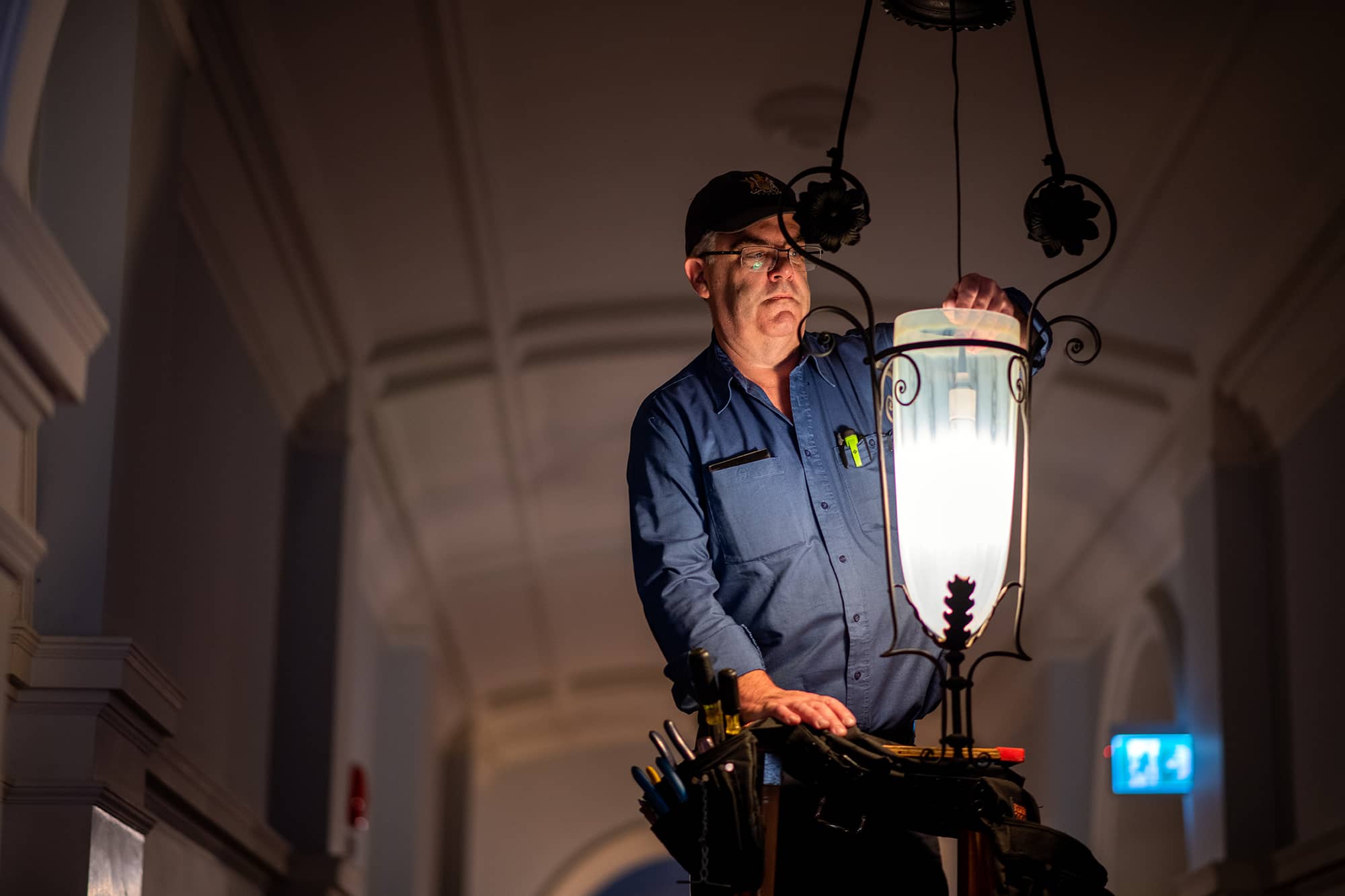 Rodney Pilatzke changes a light bulb in one of the corridors of the BC Legislature. There is a constant effort to update and modernize parts of the building, while also working to maintain and preserve its history. Photo: James MacDonald / Capital Daily