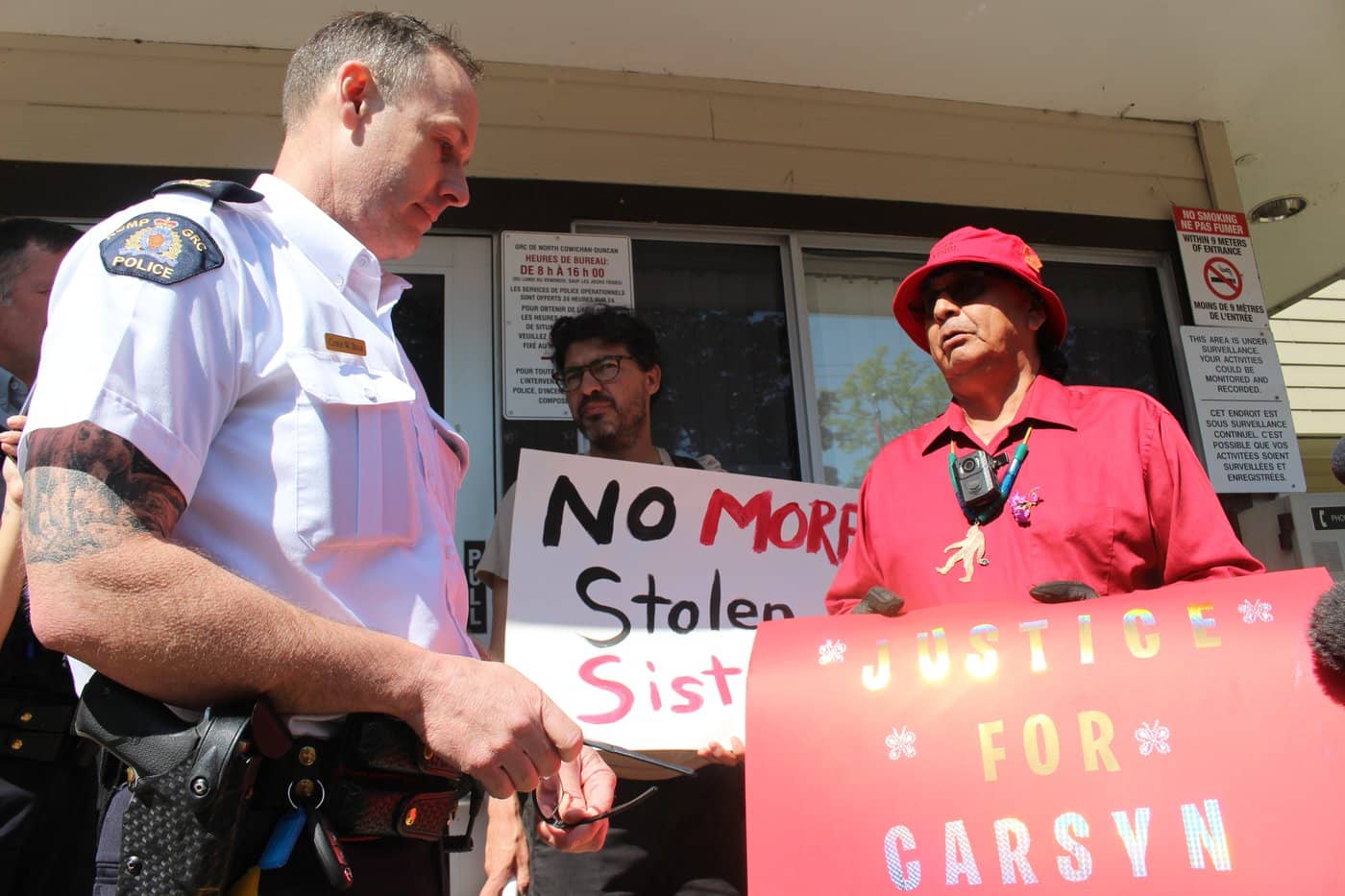 Insp. Chris Bear, left, addresses advocates including rally co-organizer Adrian Sylvester, right, on May 26. Photo by Shalu Mehta
