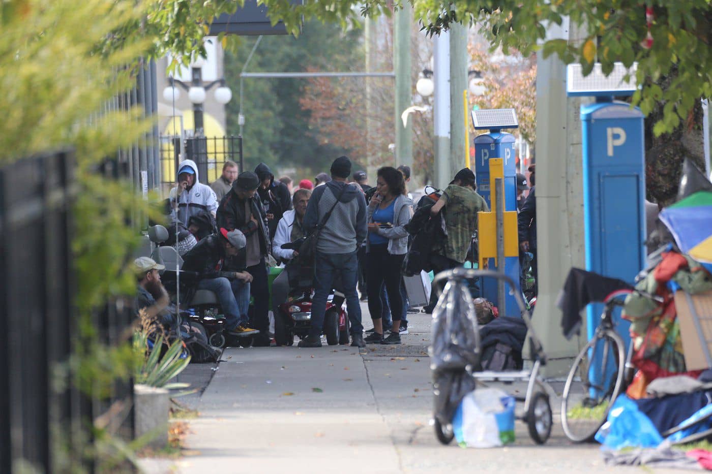 A crowd gathers in front of a safe consumption site on Pandora Avenue in Victoria. Phot: Eric Plummer