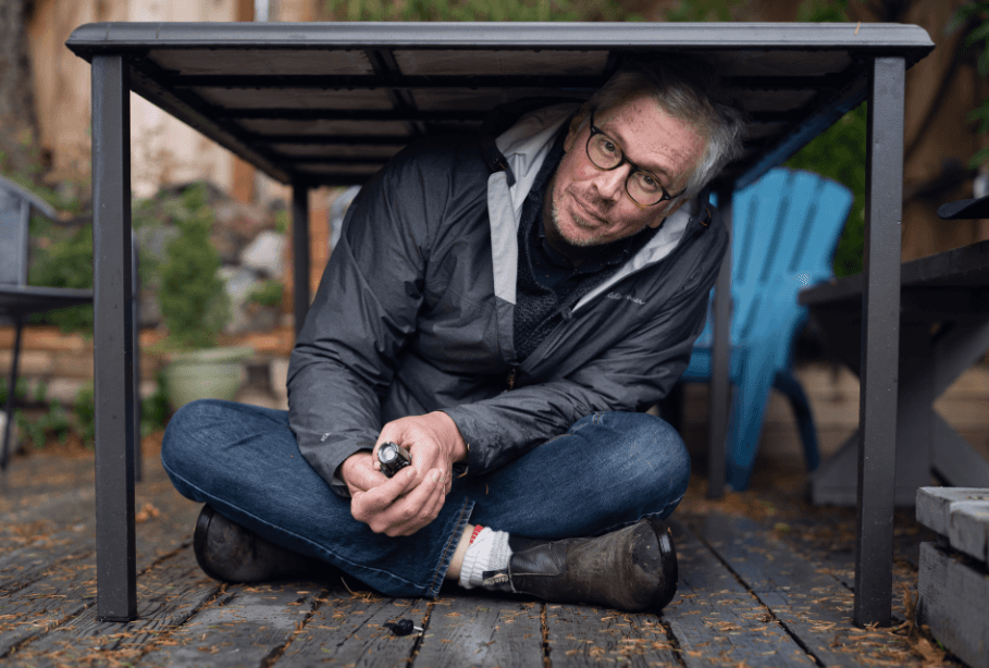 CBC's Gregor Craigie under a desk. Craigie recently authored On Borrowed Time: North America's Next Big Quake. Photo: Jimmy Thomson / Capital Daily