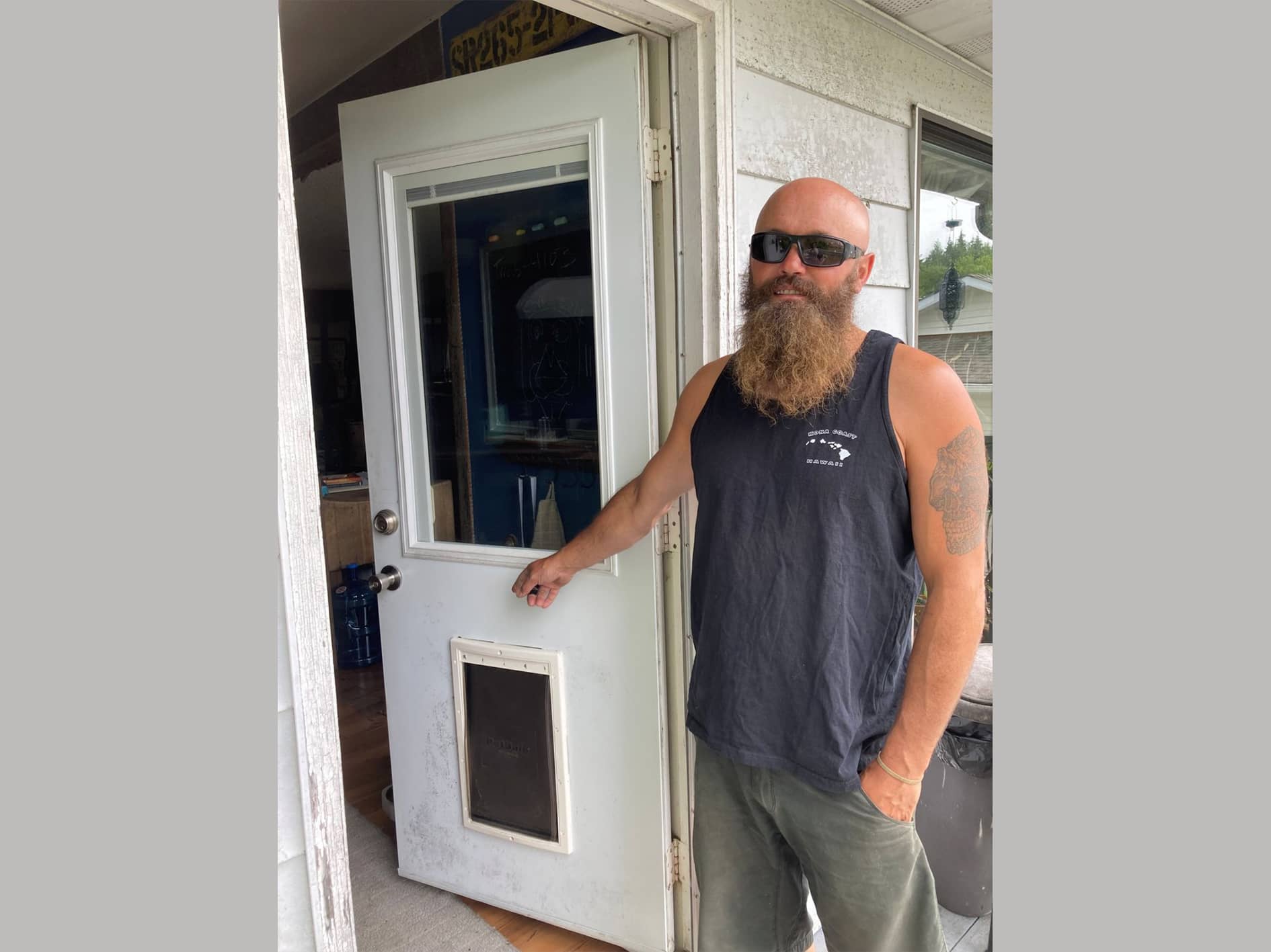 Ucluelet homeowner Brandon Halvorson stands beside the dog door a bear used to enter his house around July 17 or 18. (Submitted photo)